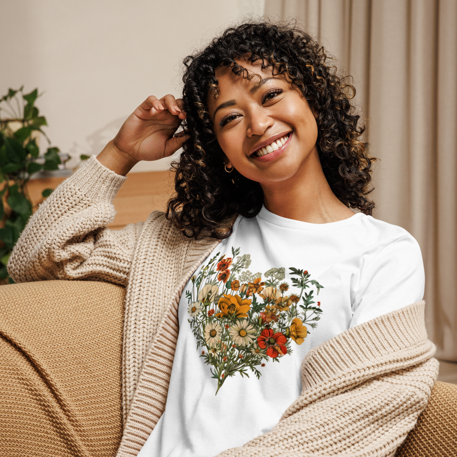 Leende kvinna i vit t-shirt med hjärtformad blomsterillustration i varma färger – ett naturligt och feminint motiv i avslappnad stil.