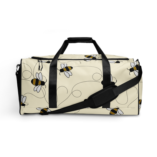 Duffelväska i polyester med svart rem och mönster av tecknade bin i svart, vitt och gult på ljus bakgrund.
Polyester duffel bag with black strap and a pattern of cartoon bees in black, white, and yellow on a light background.