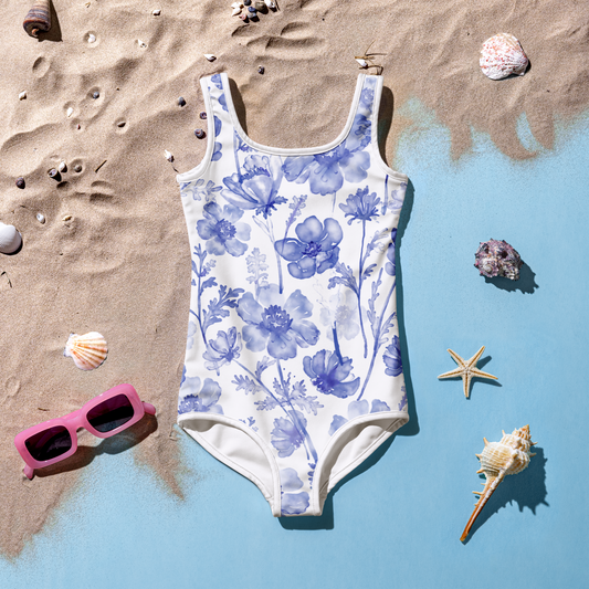 Barnbaddräkt med blå akvarellblommor på vit bakgrund.
Kids' swimsuit with blue watercolor flowers on a white background.