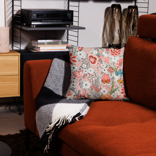 Kuddfodral med handritat retro blommönster i rött, svart och grönt på en soffa i modern inredning.45.7x45.7cm
Pillowcase with hand-drawn retro floral pattern in red, black, and green placed on a modern rust-colored sofa.45.7x45.7cm