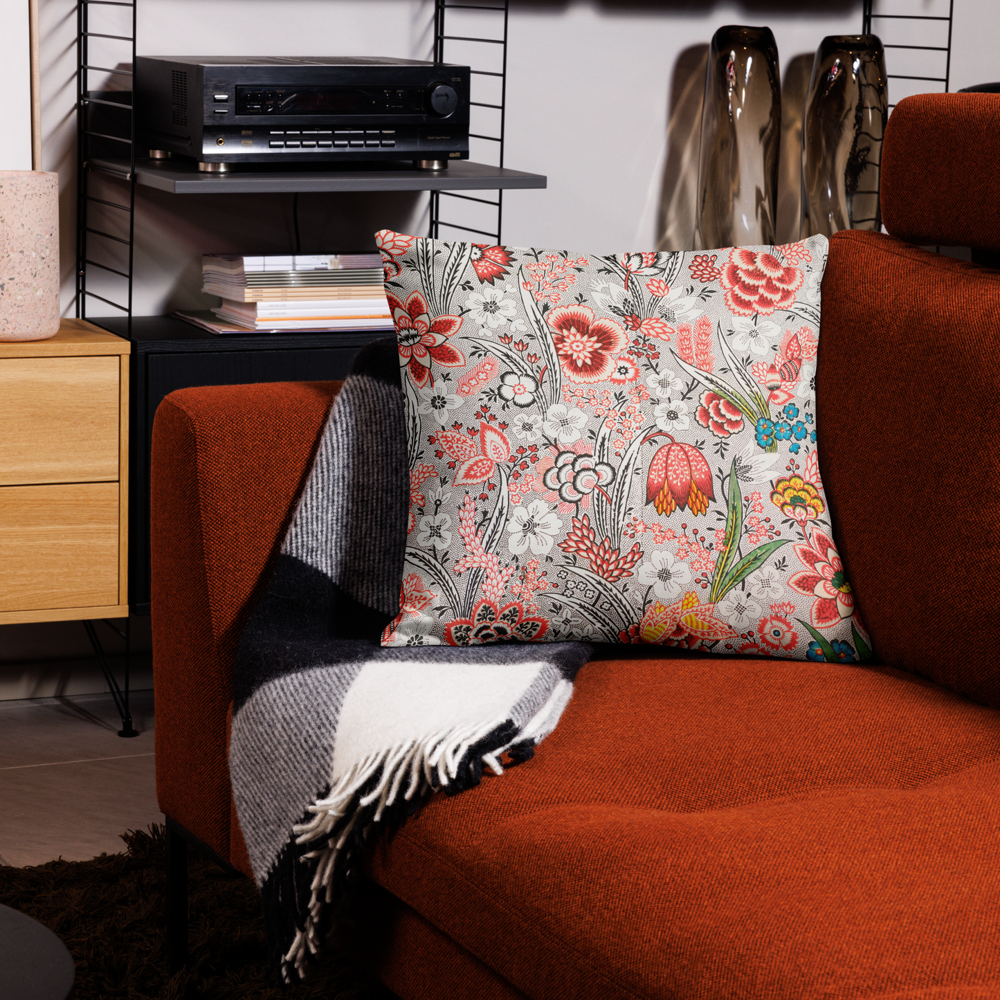 Kuddfodral med handritat retro blommönster i rött, svart och grönt på en soffa i modern inredning.55.9x55.9 cm
Pillowcase with hand-drawn retro floral pattern in red, black, and green placed on a modern rust-colored sofa. 55.9x55.9cm