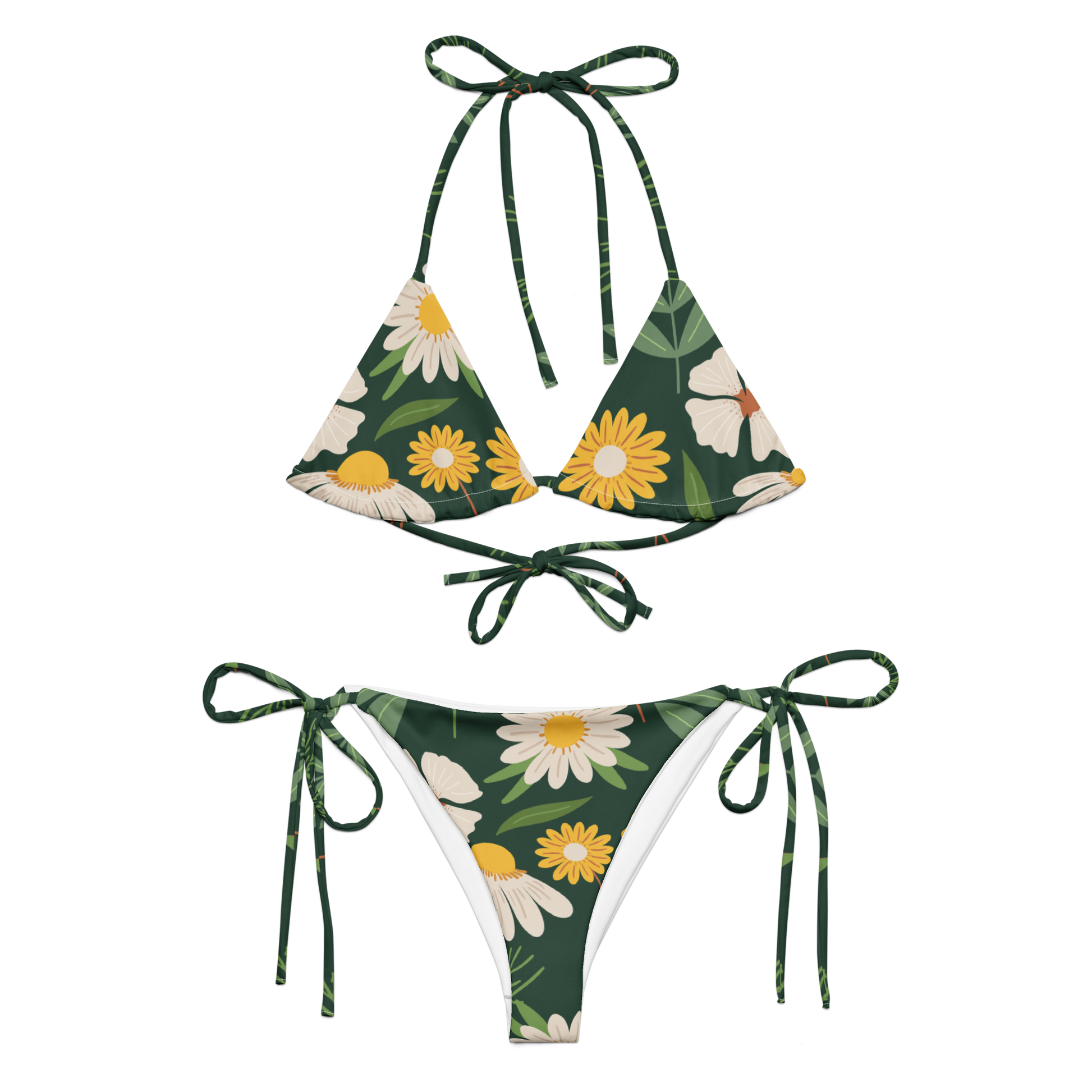 Grön stringbikini med prästkragar och blommor – tillverkad av återvunnet material, mot grön bakgrund.
Green string bikini with daisies and floral print – made from recycled material, on a green background.
