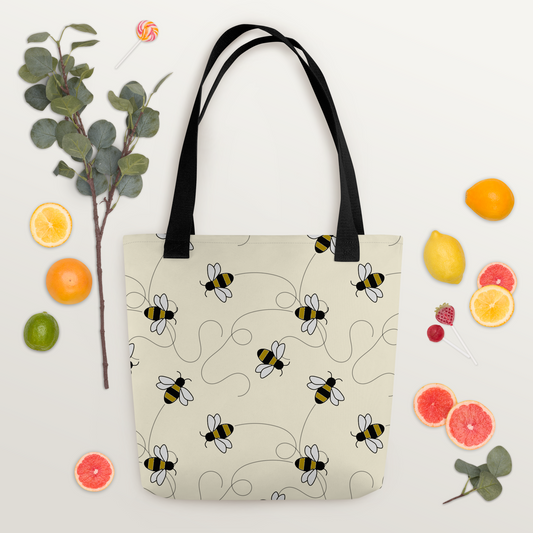 Ljus polyester-tygväska med svart handtag och lekfullt mönster av tecknade bin i svart, gult och vitt.
Light-colored polyester tote bag with black handle and playful pattern of cartoon bees in black, yellow, and white.