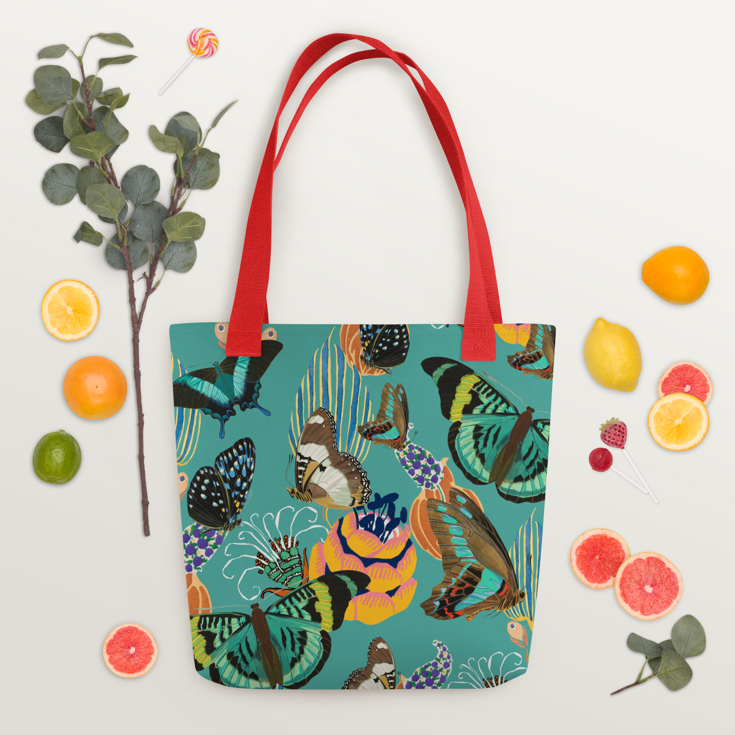 Tygväska i polyester med röda handtag och ett färgglatt all-over-mönster av fjärilar och blommor på turkos bakgrund.
Polyester tote bag with red handles and a vibrant all-over pattern of butterflies and flowers on a turquoise background.