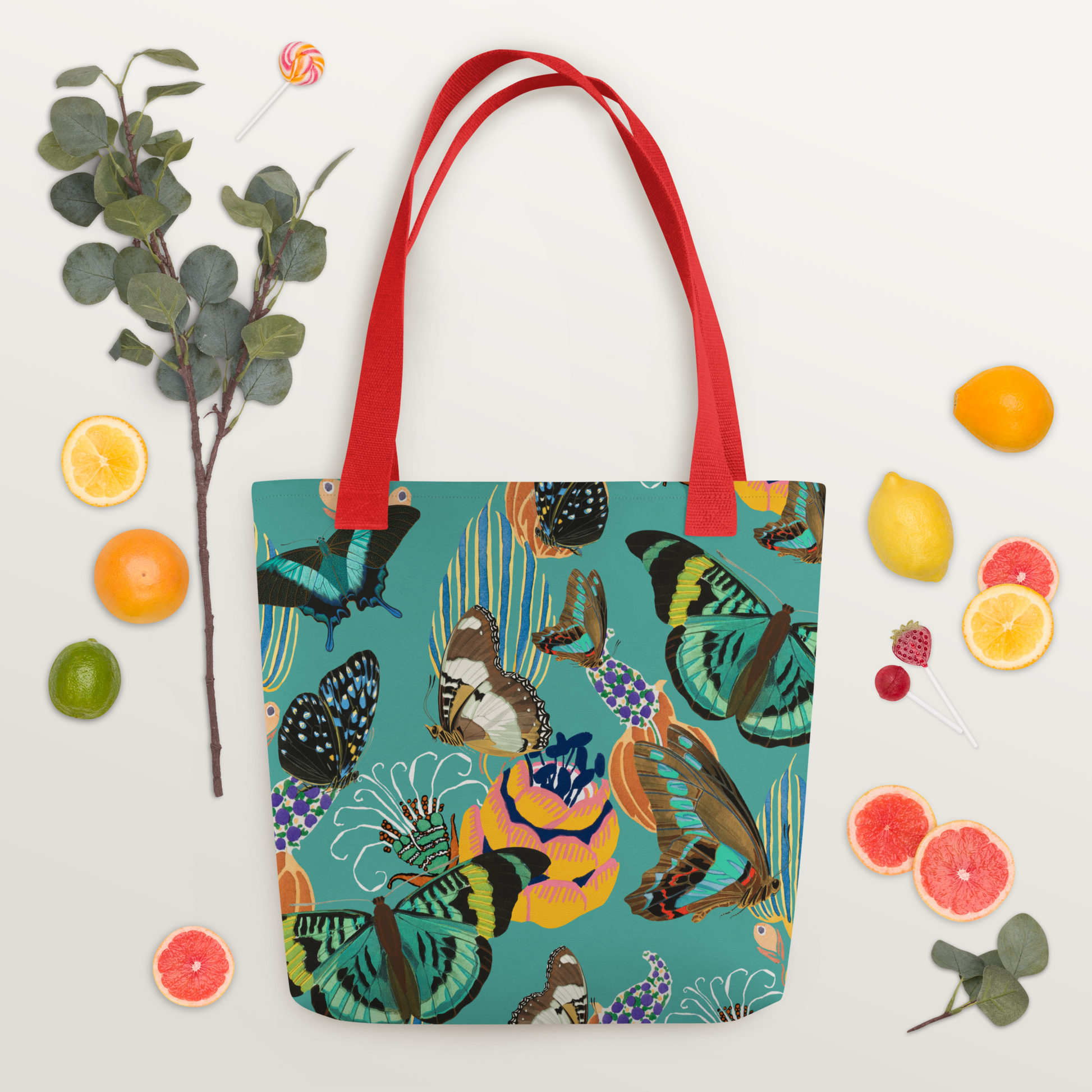 Tygväska i polyester med röda handtag och ett färgglatt all-over-mönster av fjärilar och blommor på turkos bakgrund.
Polyester tote bag with red handles and a vibrant all-over pattern of butterflies and flowers on a turquoise background.