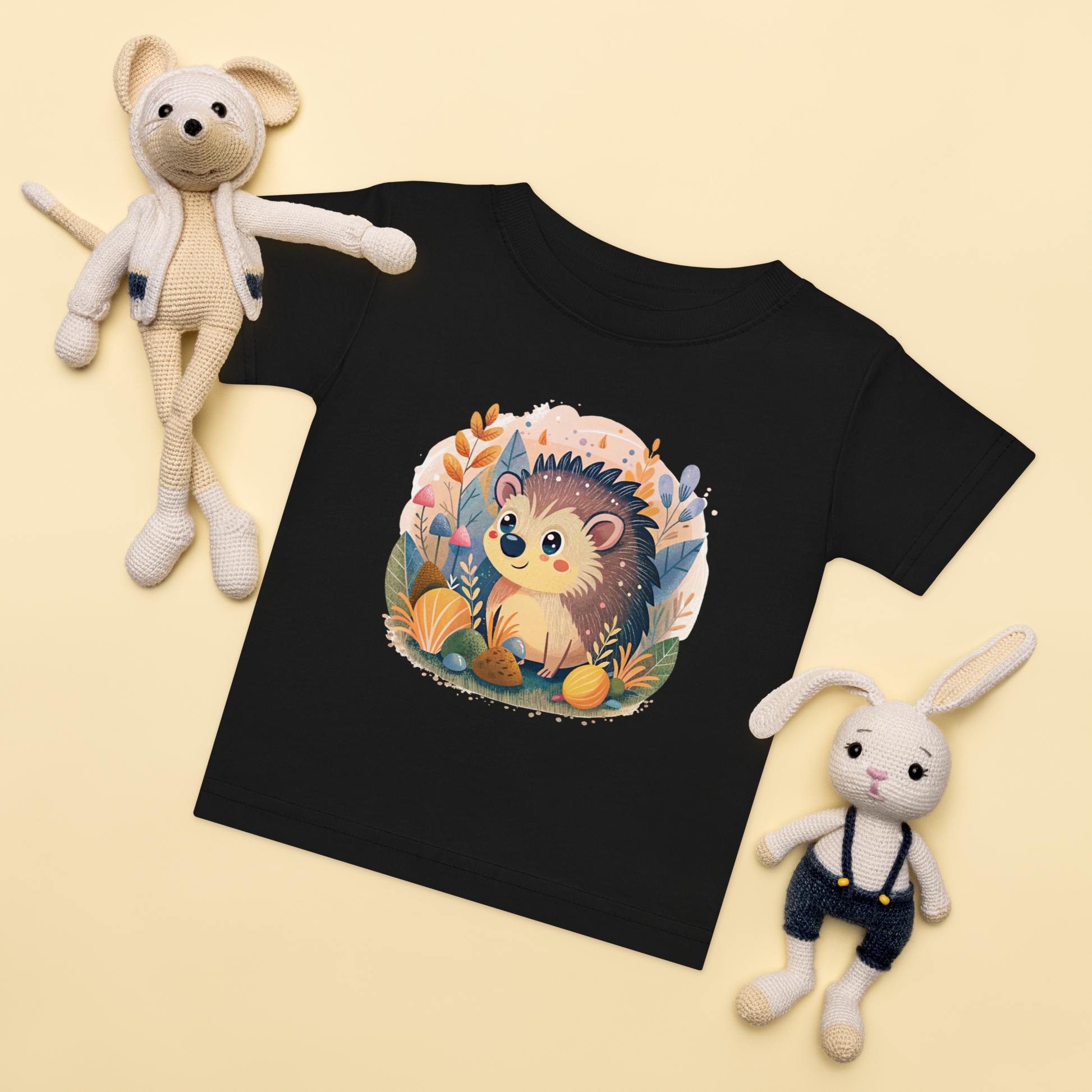 Baby t-shirt in black with a hand-drawn hedgehog and forest elements on the front.
Baby-t-shirt i svart med handritad igelkott och skogselement framtill.