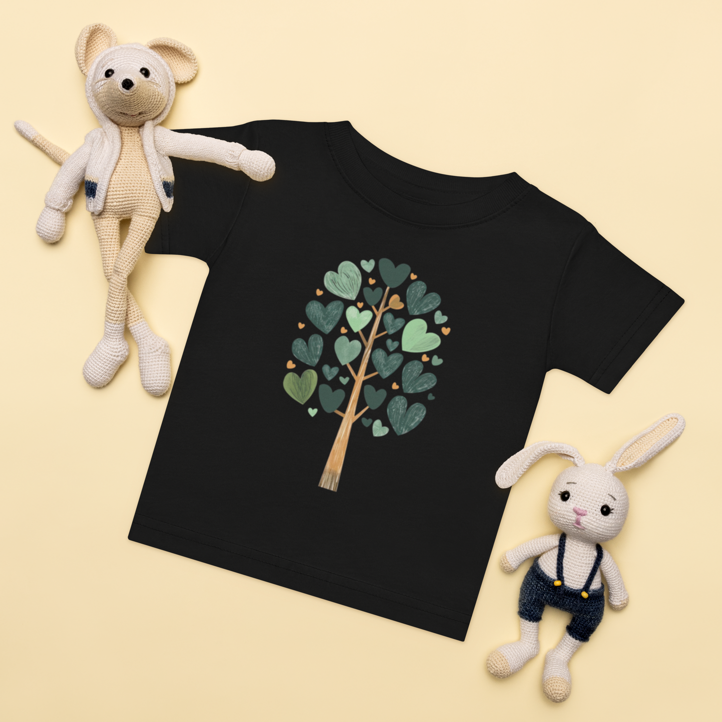 Baby-t-shirt i svart med ett träd av gröna hjärtan framtill.
Baby t-shirt in black with a heart-shaped leaf tree illustration on the front.
