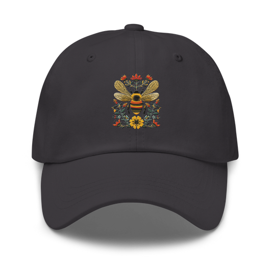 Mörkgrå pappa keps med broderat bi och blommor på framsidan.
Dark grey dad hat with embroidered bee and flowers on the front.
