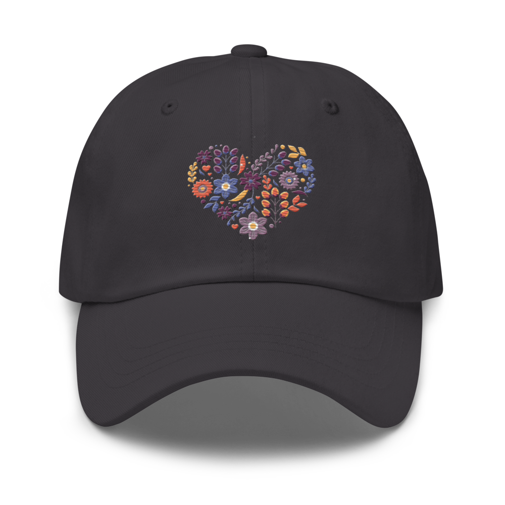 Mörkgrå pappakeps med ett broderat hjärta bestående av färgglada små blommor.
Dark grey dad hat with an embroidered heart made up of colorful little flowers.