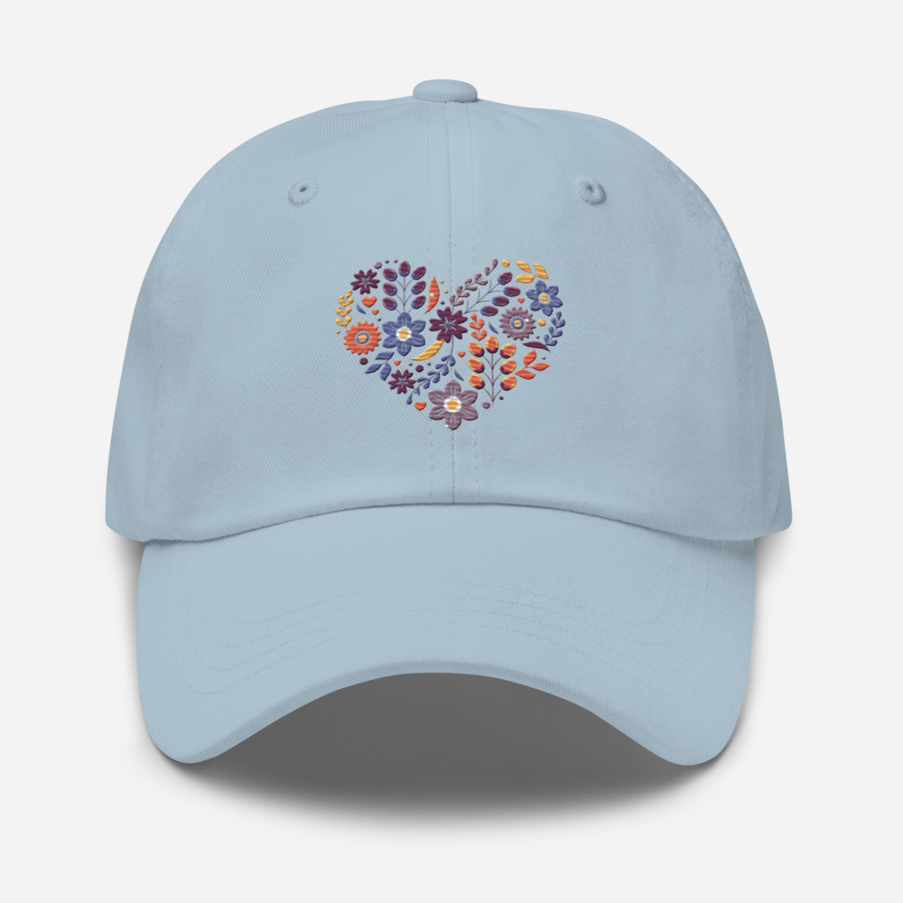 Ljusblå pappakeps med ett broderat hjärta bestående av färgglada små blommor.
Light blue dad hat with an embroidered heart made up of colorful little flowers.
