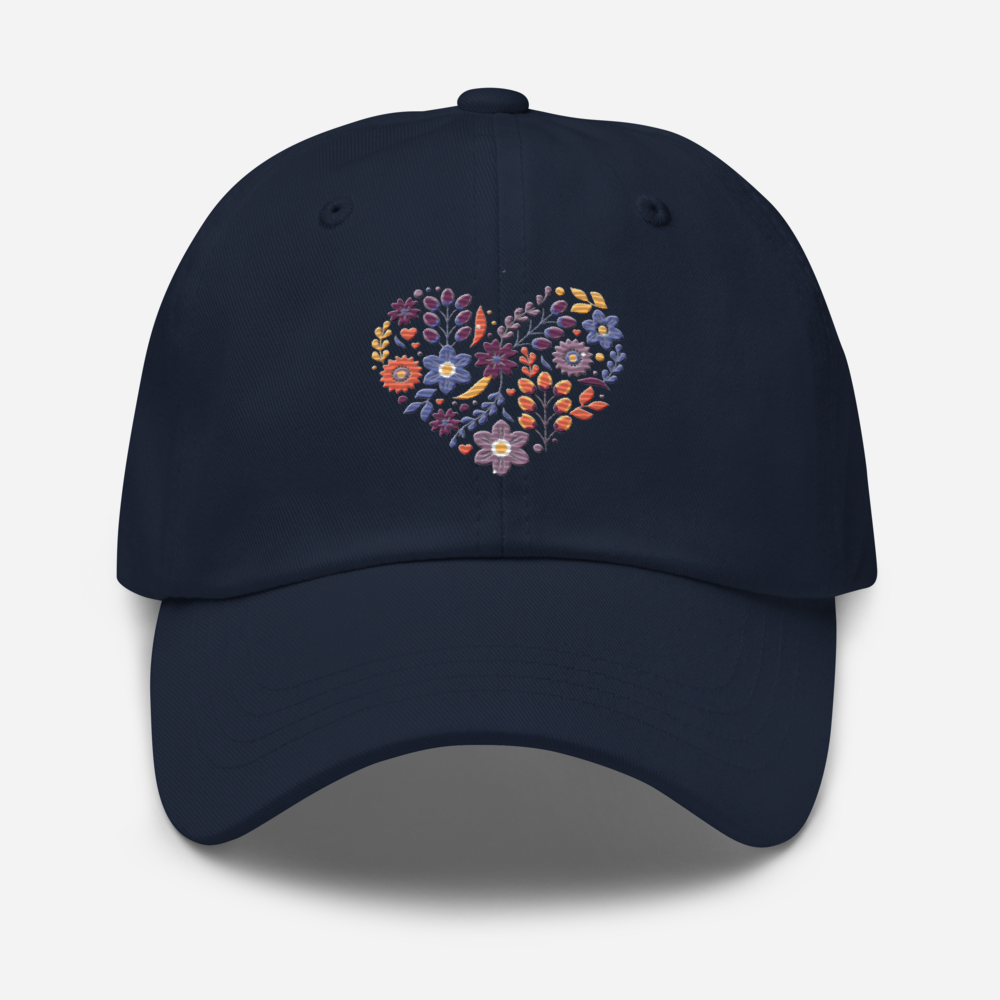 Marinblå pappakeps med ett broderat hjärta bestående av färgglada små blommor.
Navy dad hat with an embroidered heart made up of colorful little flowers.