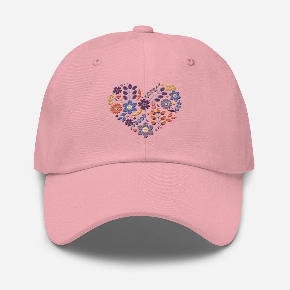 Rosa pappakeps med ett broderat hjärta bestående av färgglada små blommor.
Pink dad hat with an embroidered heart made up of colorful little flowers.