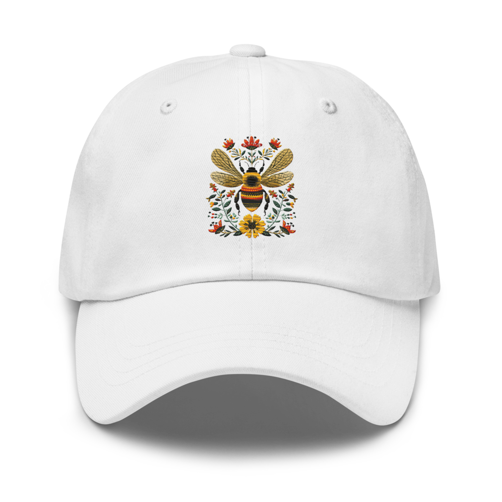 Vit pappa keps med broderat bi och blommor på framsidan.
White dad hat with embroidered bee and flowers on the front.