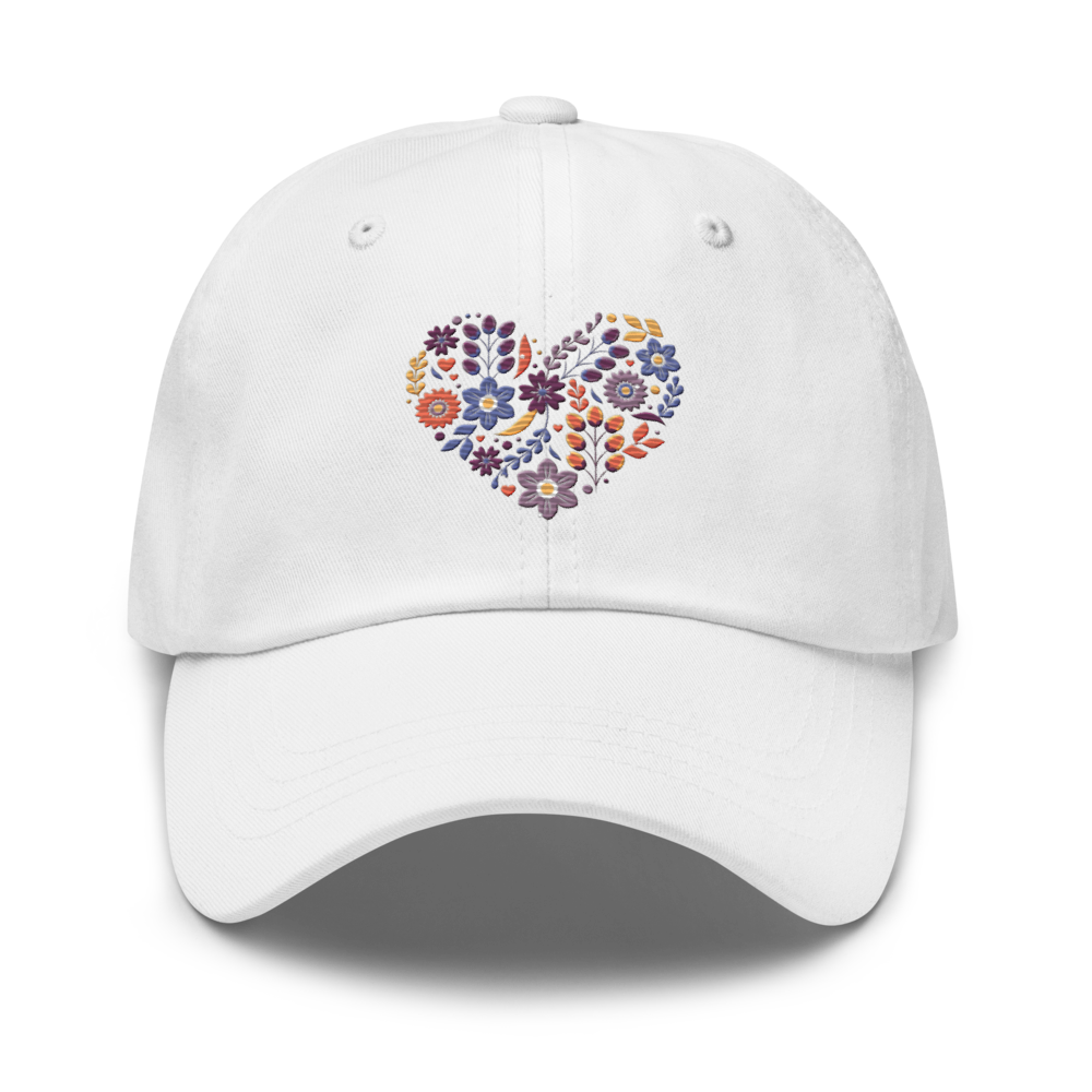Vit pappakeps med ett broderat hjärta bestående av färgglada små blommor.
White dad hat with an embroidered heart made up of colorful little flowers.