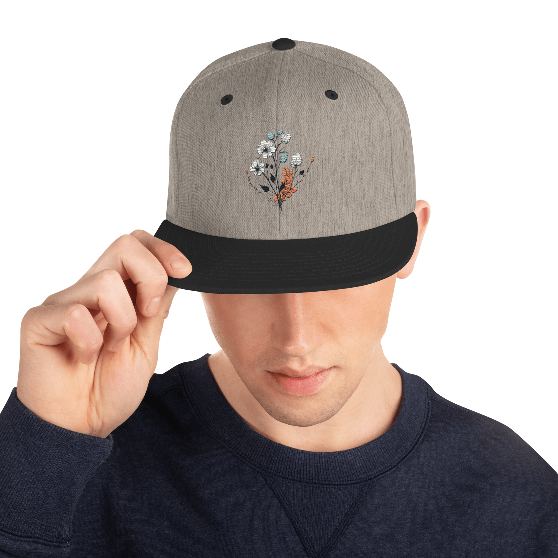 Melerad grå snapback keps med svart skärm och broderad blomdesign framtill
Heather grey snapback cap with black brim and embroidered floral design on the front.