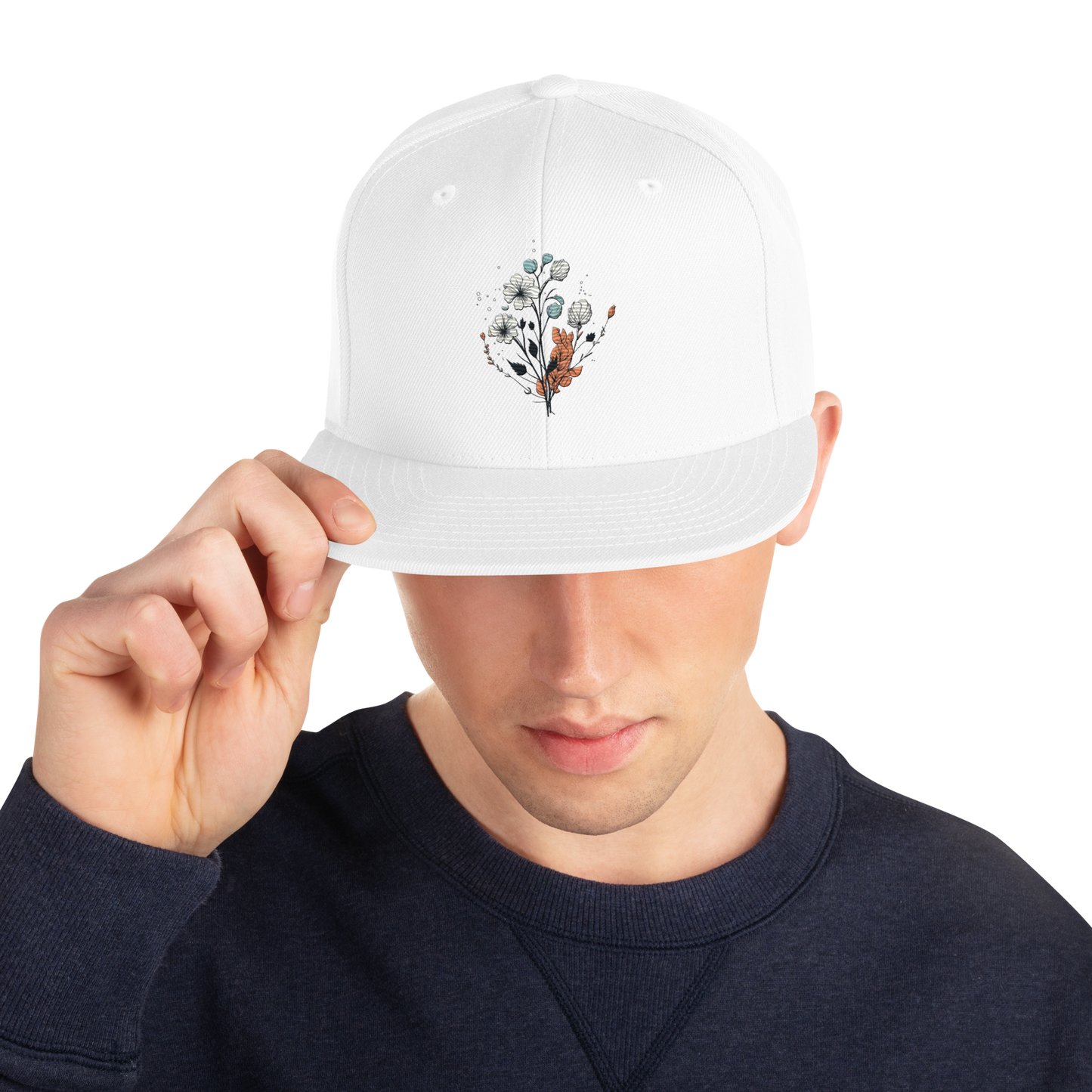Vit snapback keps med broderad blomdesign framtill.
White snapback cap with embroidered floral design on the front.