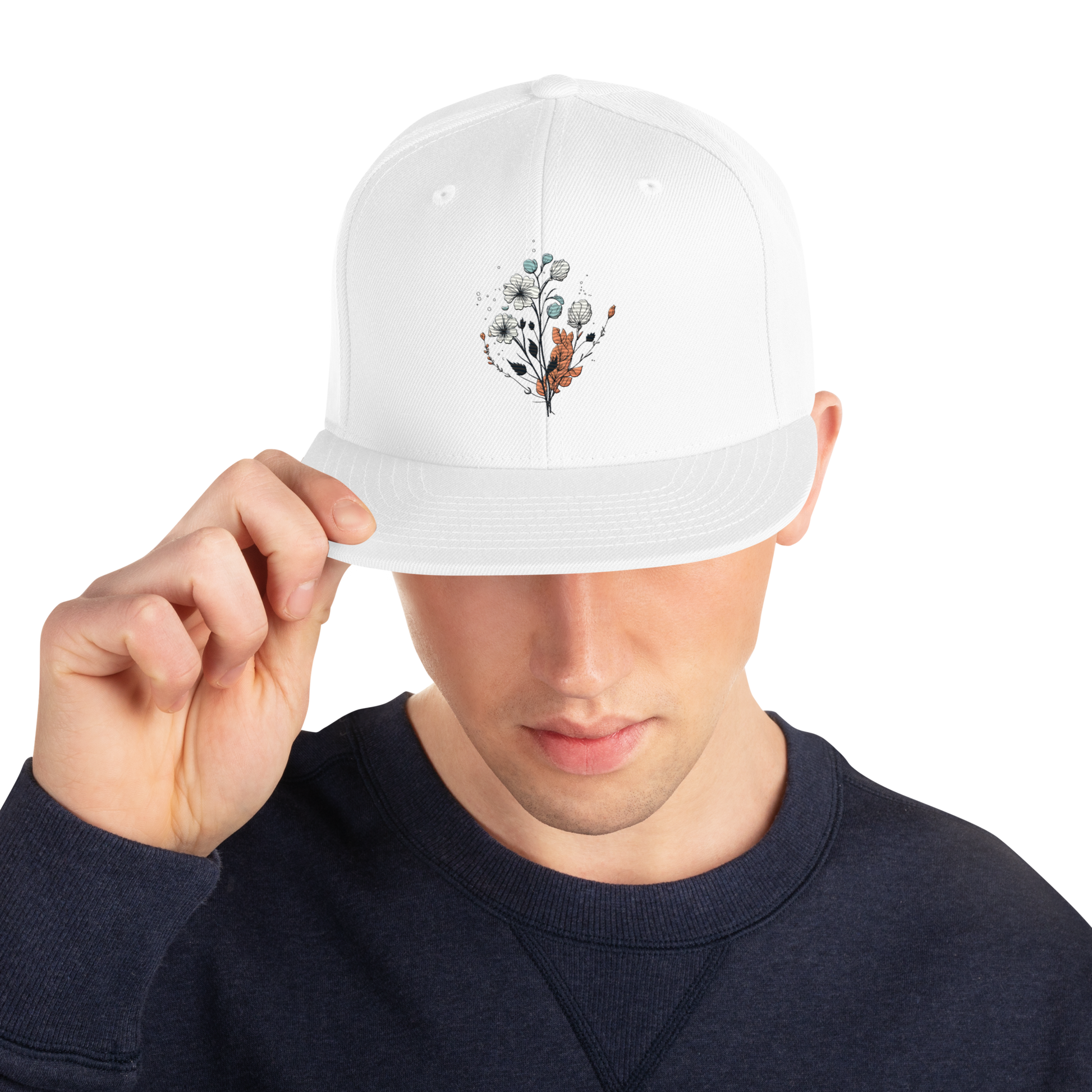 Vit snapback keps med broderad blomdesign framtill.
White snapback cap with embroidered floral design on the front.