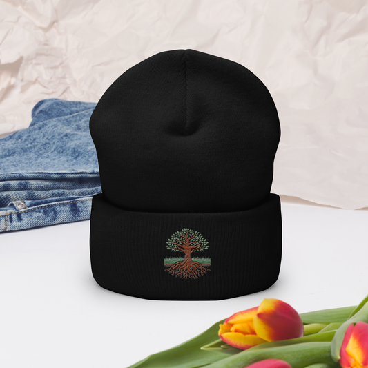 Svart uppvikt mössa med broderat träd och rötter i grönt och brunt framtill.
Black cuffed beanie with embroidered tree and roots in green and brown on the front.