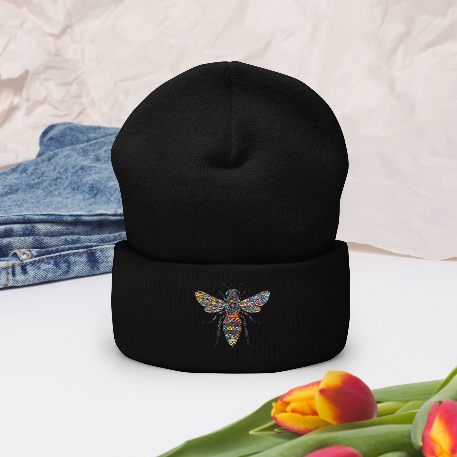 Svart uppvikt mössa med broderad bi i flerfärg framtill.
Black cuffed beanie with multicolored embroidered bee on the front.