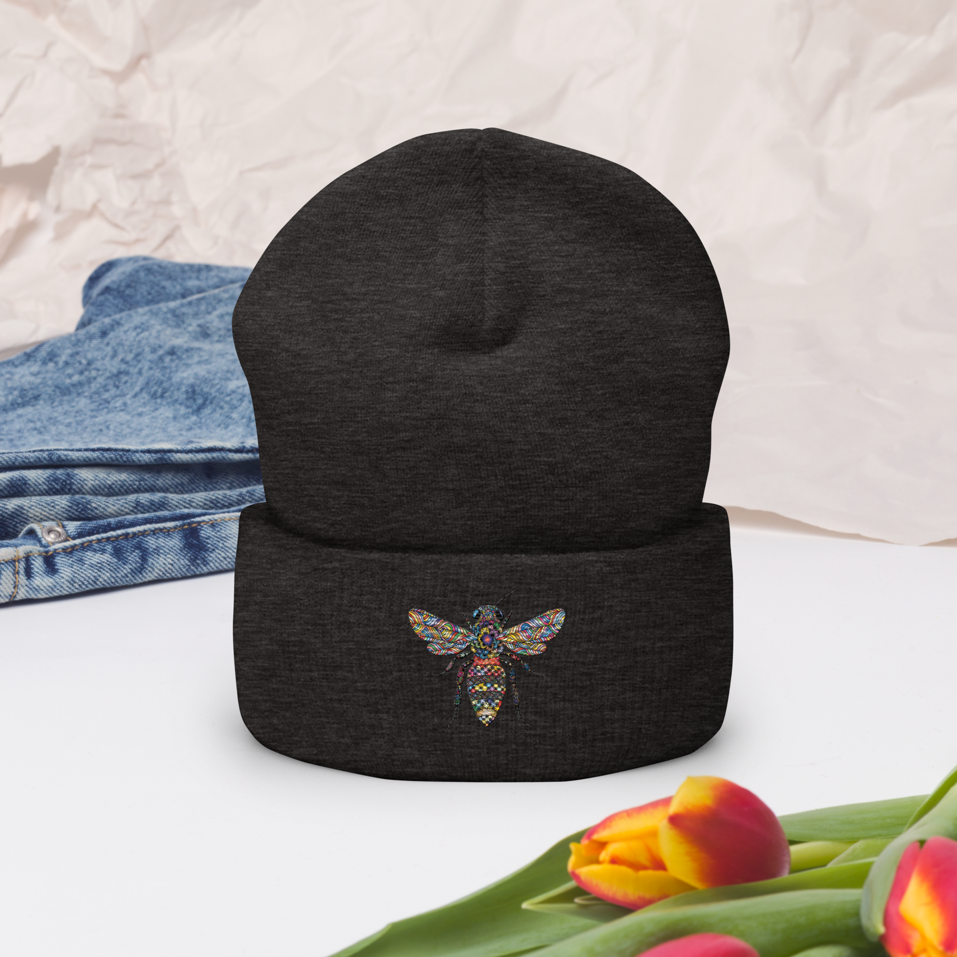 Mörkgrå uppvikt mössa med broderad bi i flerfärg framtill.
Dark grey cuffed beanie with multicolored embroidered bee on the front.