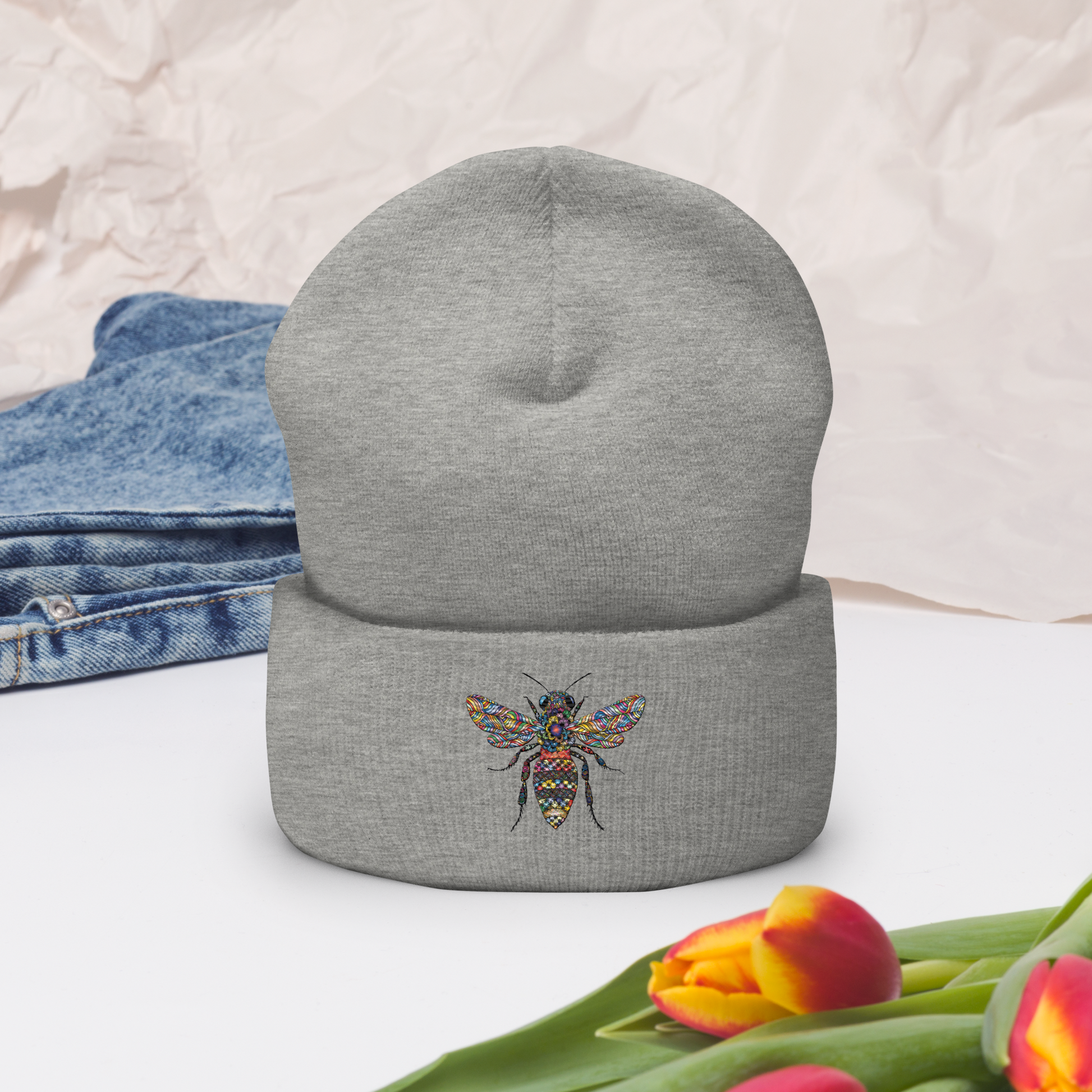 Gråmelerad uppvikt mössa med broderad bi i flerfärg framtill.
Heather grey cuffed beanie with multicolored embroidered bee on the front.