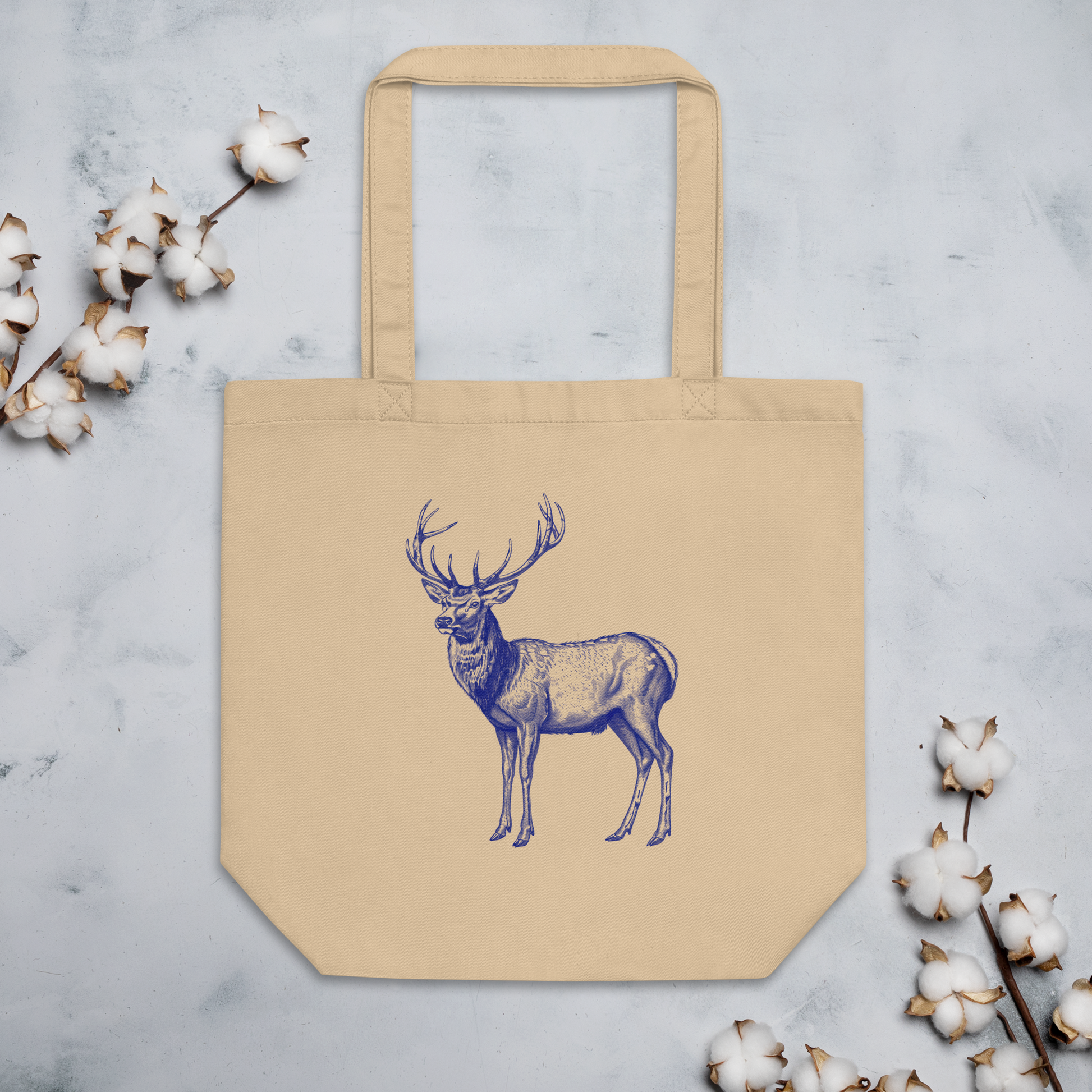 Ekologisk tygväska i naturfärg med blå hjortillustration i klassisk stil.
Eco-friendly cotton tote bag in natural color with a classic blue deer illustration.