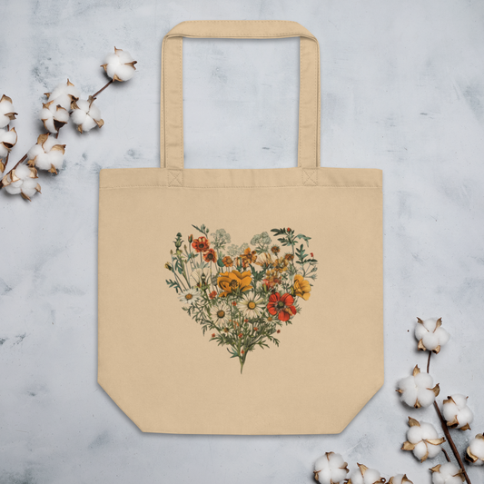 Naturfärgad beige ekologisk tygväska med ett hjärta av färgglada vilda blommor tryckt i mitten.
Natural-colored oyster organic tote bag featuring a heart made of colorful wildflowers printed in the center.