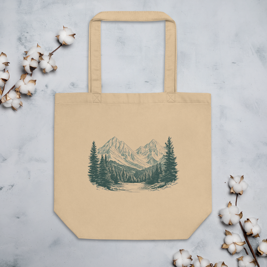 Ekologisk tygpåse i naturfärg med tryck av skog och fjäll i grönblå toner.
Natural-colored organic tote bag with a forest and mountain print in greenish-blue tones