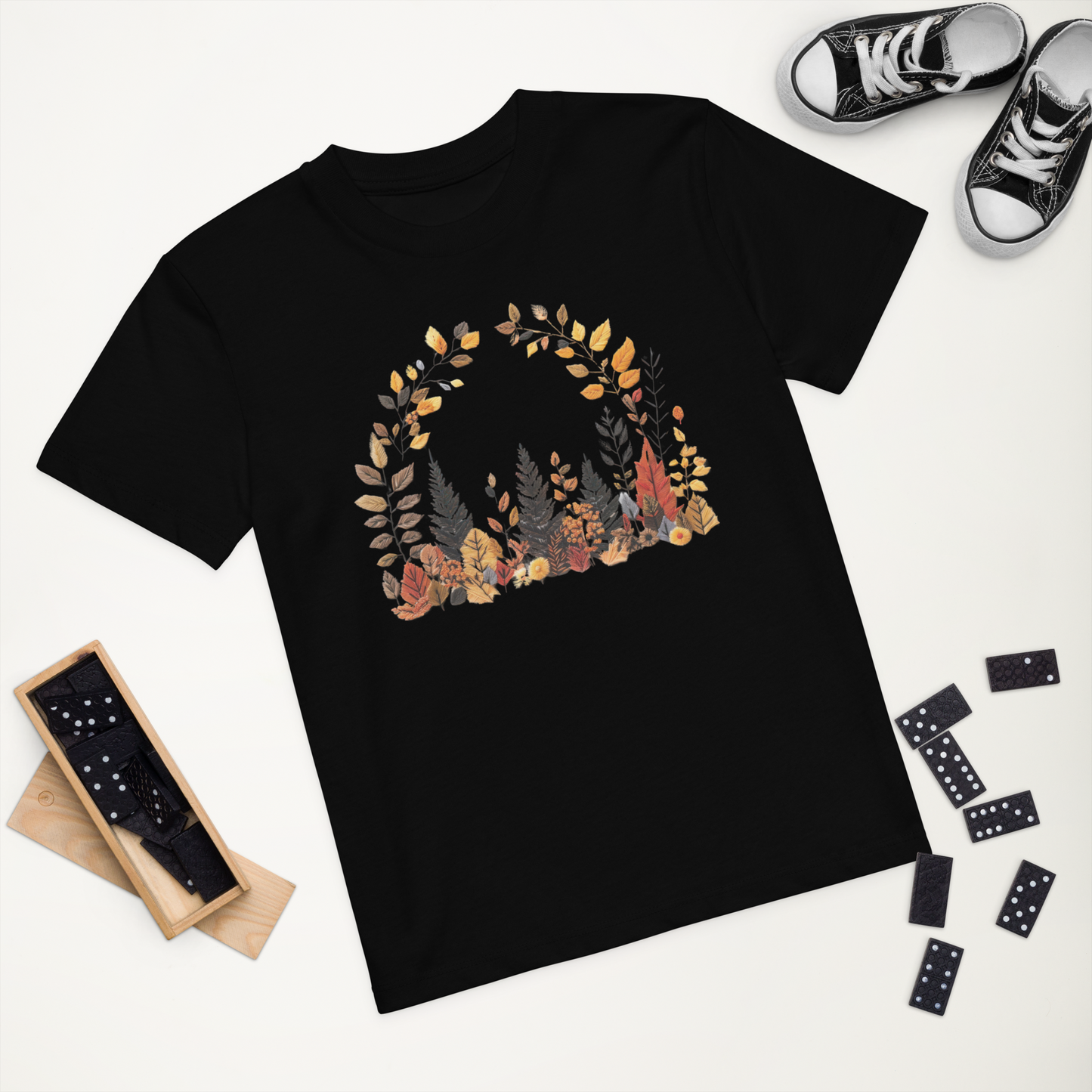 Svart ekologisk barn-t-shirt med tryckta höstlöv i broderieffekt framtill.
Black organic kids t-shirt with printed autumn leaves in embroidery effect on the front.