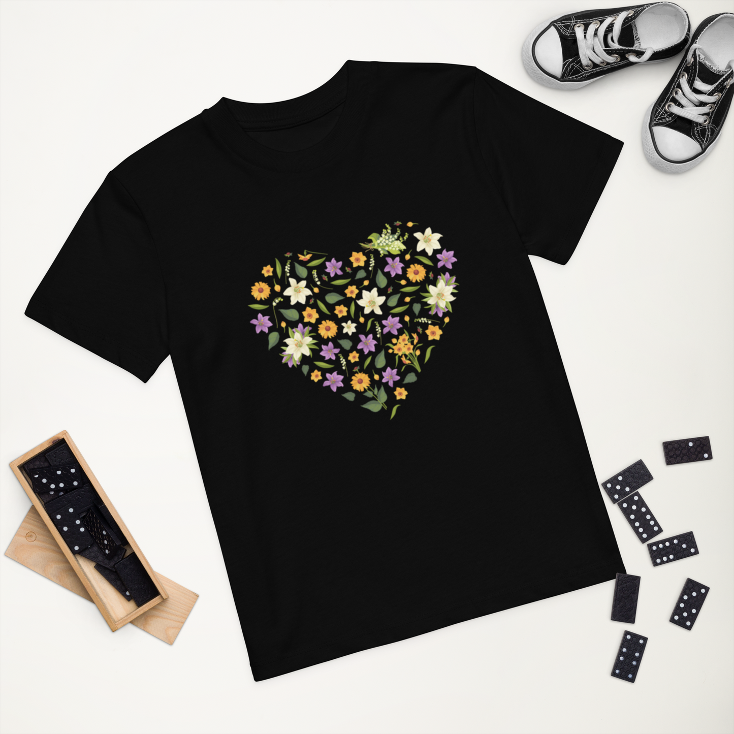 Svart ekologisk barn-t-shirt med hjärta av färgglada blommor framtill.
Black organic kids t-shirt with a heart-shaped floral design on the front.