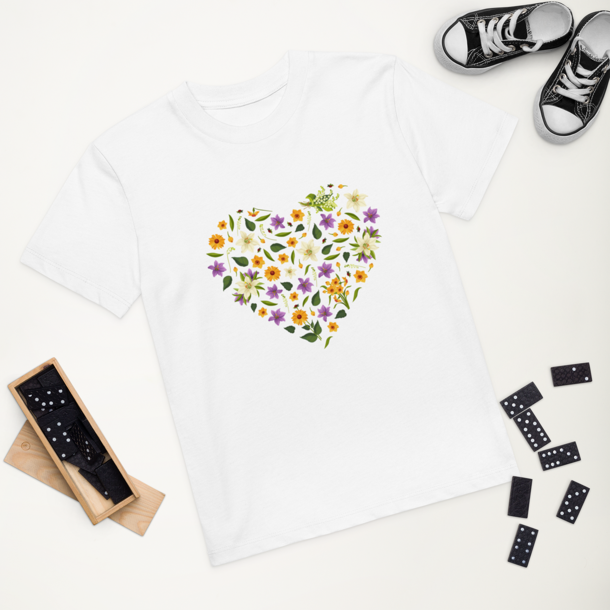 Vit ekologisk barn-t-shirt med hjärta av färgglada blommor framtill.
White organic kids t-shirt with a heart-shaped floral design on the front.