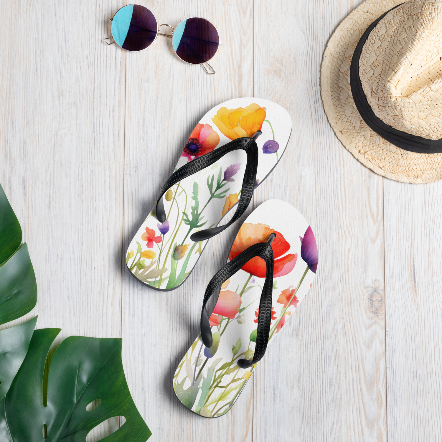 Färgglada flip-flops med blommotiv i akvarellstil och svarta Y-formade remmar.
Colorful flip-flops with a watercolor floral pattern and black Y-shaped straps