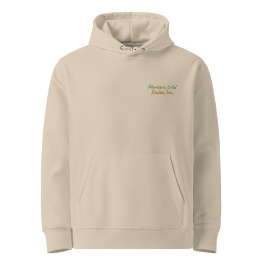 Sandfärgad ekologisk unisex hoodie med broderad text "Plantera träd, Rädda bin" på vänster bröst. Hoodien har en känguruficka, dubbla huvlager och en avslappnad passform.
Desert dust unisex eco hoodie with embroidered text "Plantera träd, Rädda bin" on the left chest. The hoodie features a kangaroo pocket, double-layer hood, and relaxed fit.