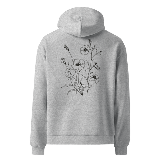Unisex oversized hoodie i grått med handritade blommor tryckta på ryggen, visad bakifrån.
Unisex oversized grey hoodie with hand-drawn floral print on the back, shown from behind