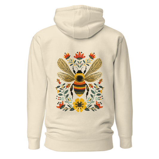 Benvit unisex hoodie med ett färgstarkt handritat bimotiv och blommor i folkart-stil tryckt på ryggen.
Bone unisex hoodie with a colorful hand-drawn bee and floral folk art-style print on the back.