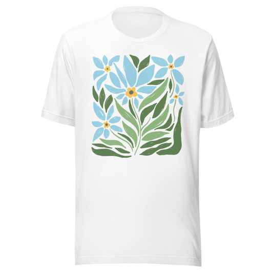 Vit unisex t-shirt med ett stiliserat motiv av blå blommor och gröna blad tryckt på framsidan.
White unisex t-shirt with a stylized design of blue flowers and green leaves printed on the front.