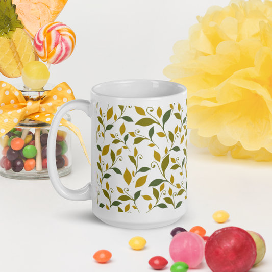 Vit blank keramikmugg 15 oz med grönt och gult lövmotiv runt om.
White glossy ceramic mug 15 oz with green and yellow leaf motif all around.
