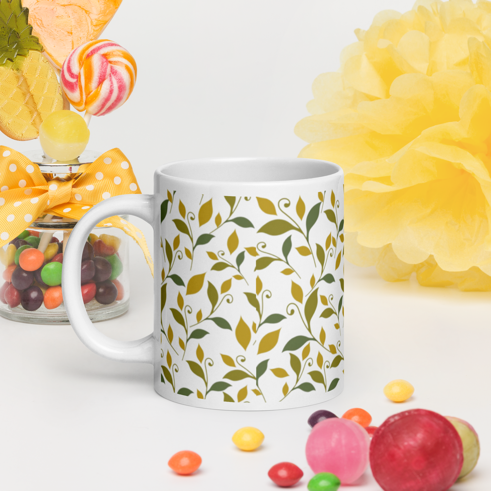Vit blank keramikmugg 20 oz med grönt och gult lövmotiv runt om.
White glossy ceramic mug 20 oz with green and yellow leaf motif all around.