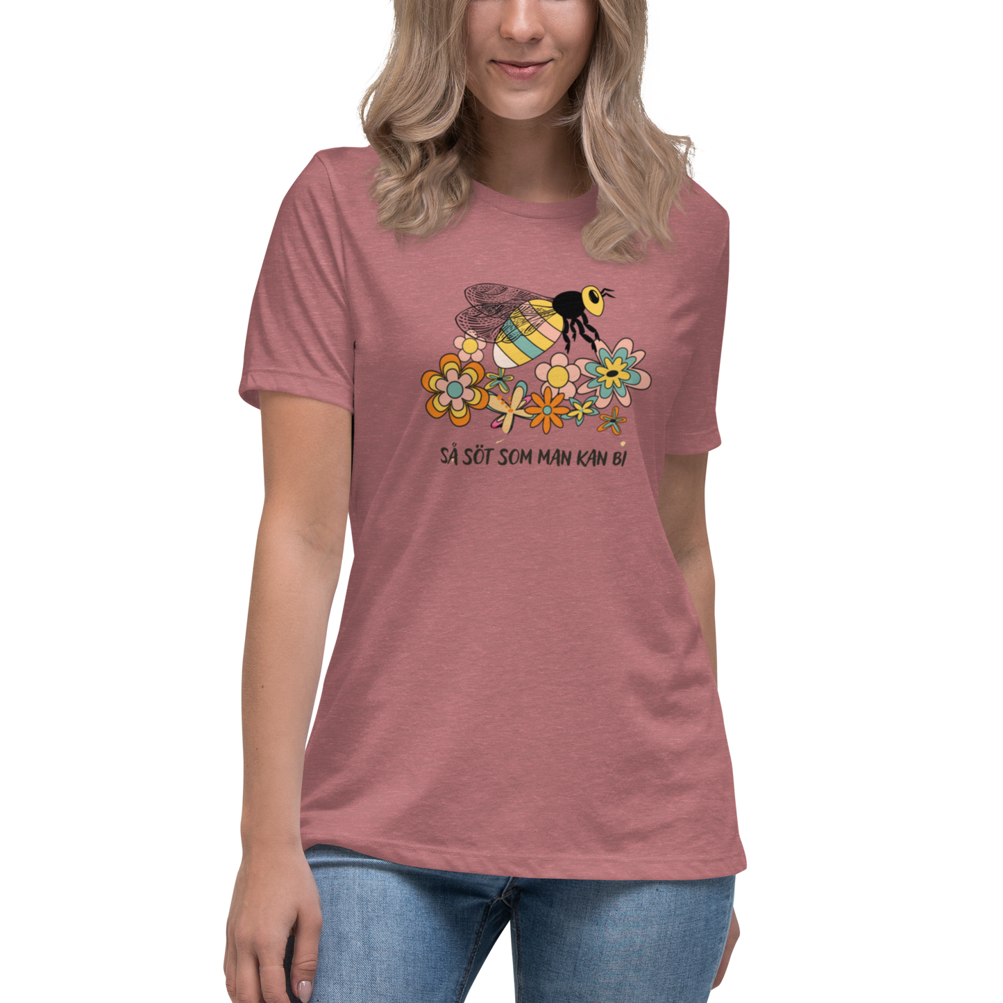 Ljungmelerad avslappnad t-shirt med en handritad bi och färgglada blommor samt texten “Så söt som man kan bi”.
Heather mavue relaxed t-shirt with a hand-drawn bee, colorful flowers, and the text “As sweet as can bee”.