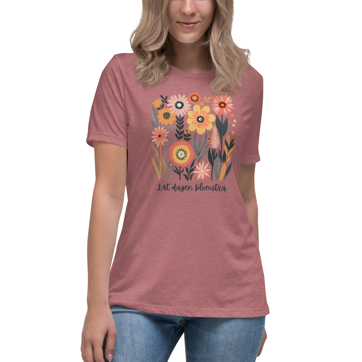 Women's relaxed fit heather mavue t-shirt with hand-drawn colorful flowers and the Swedish phrase "Låt dagen blomstra" beneath.
Ljungmelerad avslappnad dam-t-shirt med handritade färgglada blommor och den svenska texten 'Låt dagen blomstra' under motivet.
