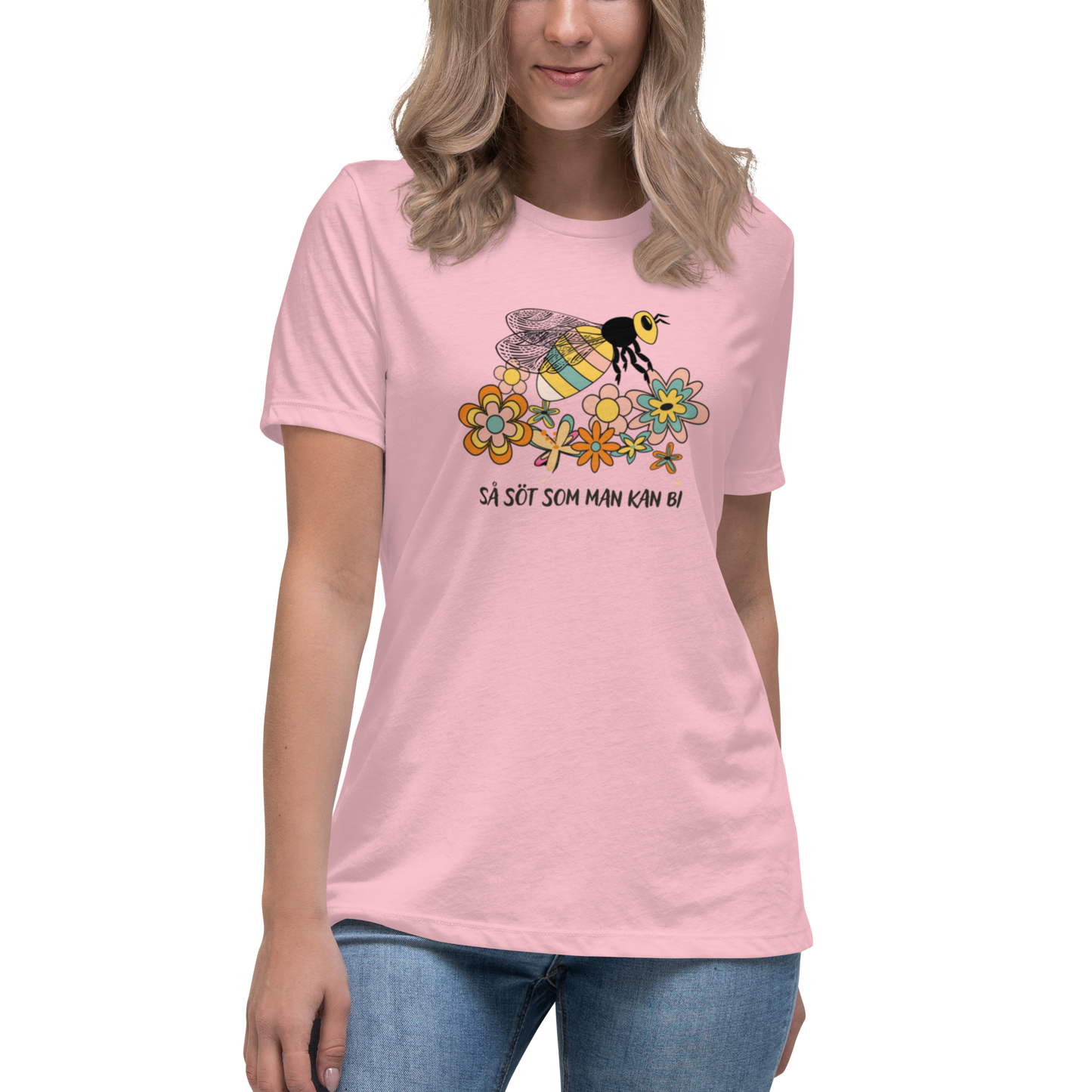 Rosa avslappnad t-shirt med en handritad bi och färgglada blommor samt texten “Så söt som man kan bi”.
Pink relaxed t-shirt with a hand-drawn bee, colorful flowers, and the text “As sweet as can bee”.